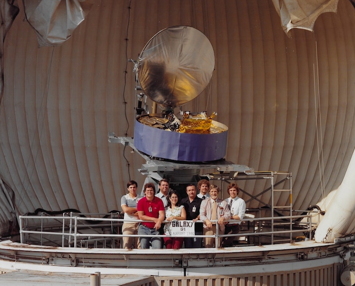 1982 Radomes on top of building S-12 Hughes Aircraft Co El Segundo CA Maureen Meyer and fellow engineers and technicians in front of Galaxy G-1 Satellite this was the antenna that went on the Galaxy G-1 Satellite